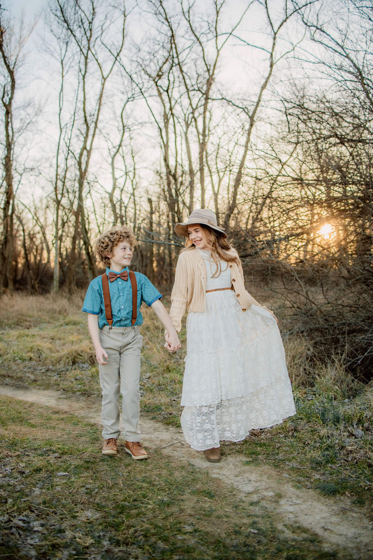 St. Louis Photographer captures a young boy and girl walking hand in hand at sunset.
