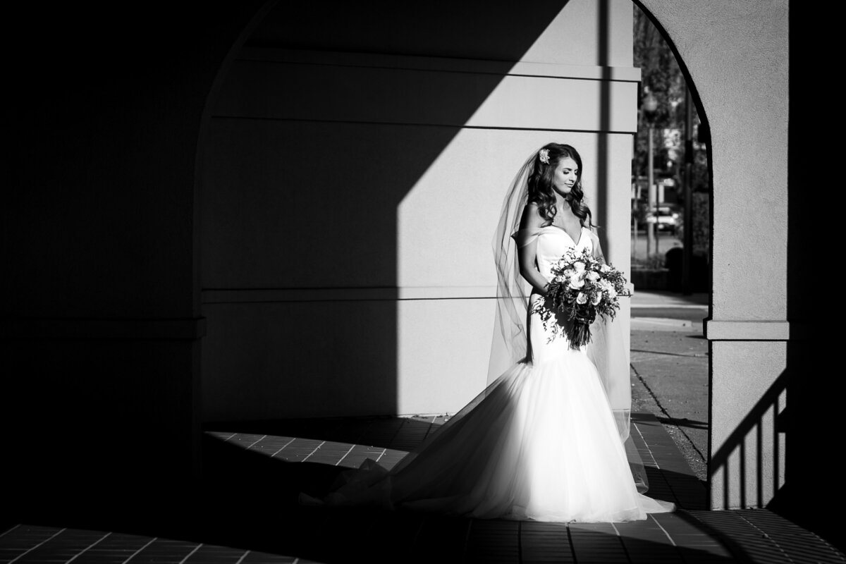 black and white image of bride in arch light opening