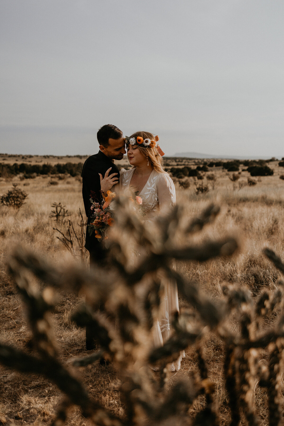 bride and groom holding each other in the desert