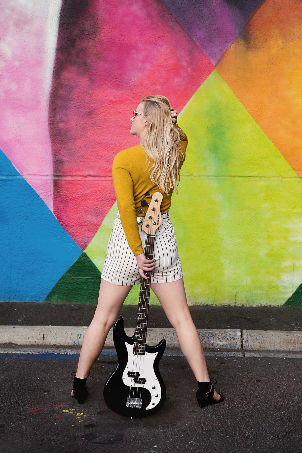 Maple Grove Minnesota senior photo of musician against a colorful mural wall in Minneapolis
