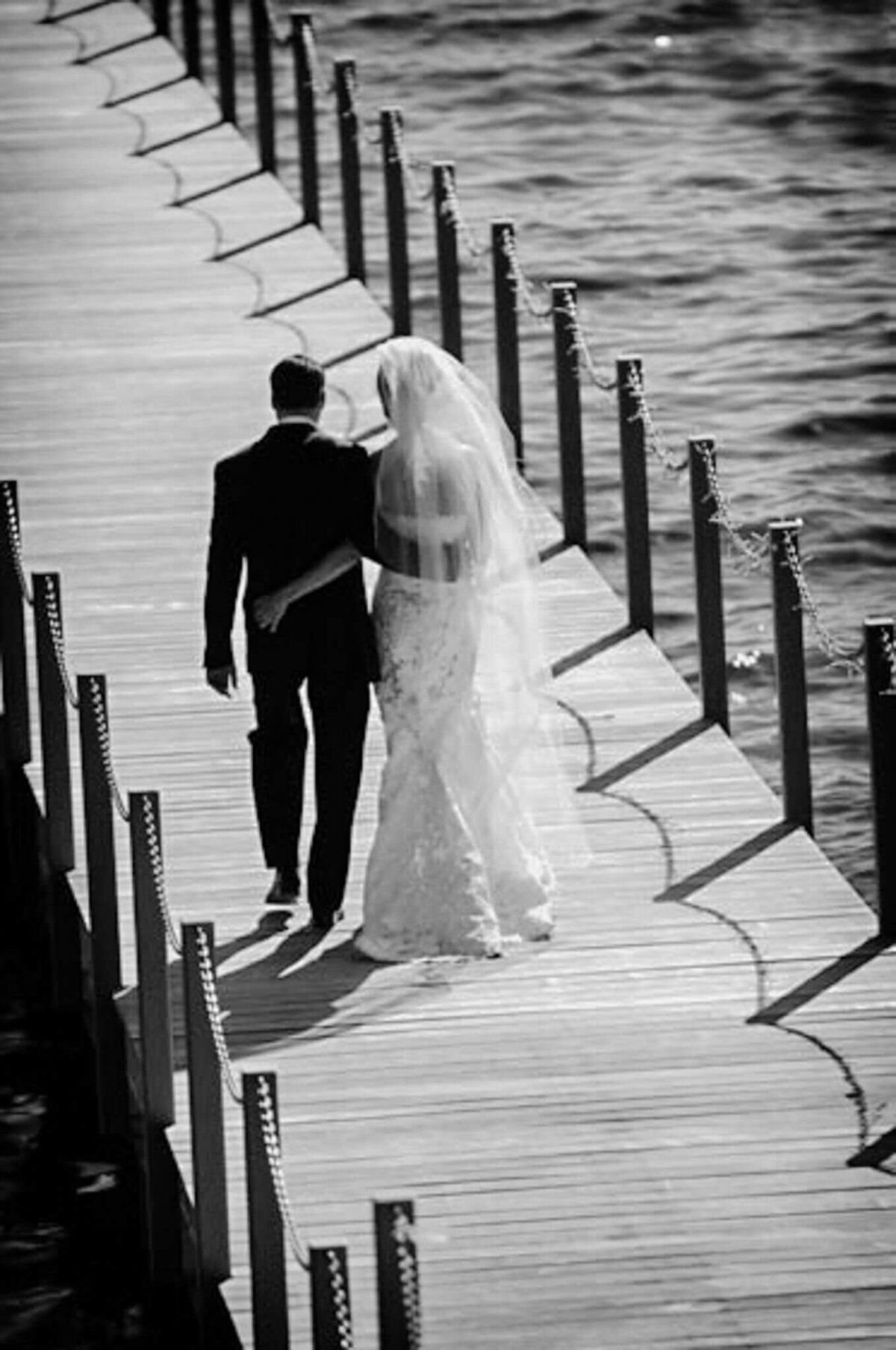 couple just married walking out on a pier in Lake Tahoe. Black and white image