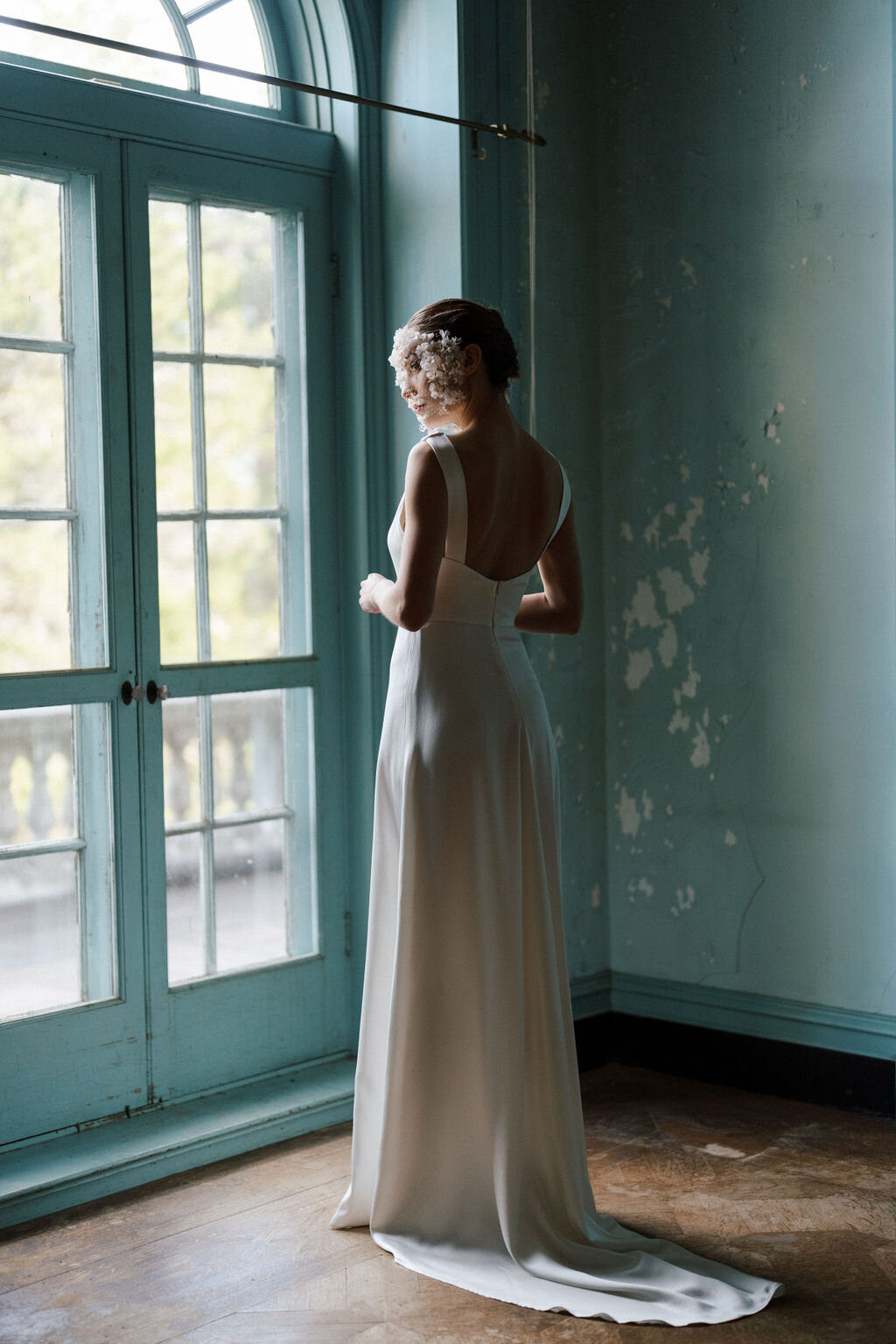 bride looking out window in wedding dress