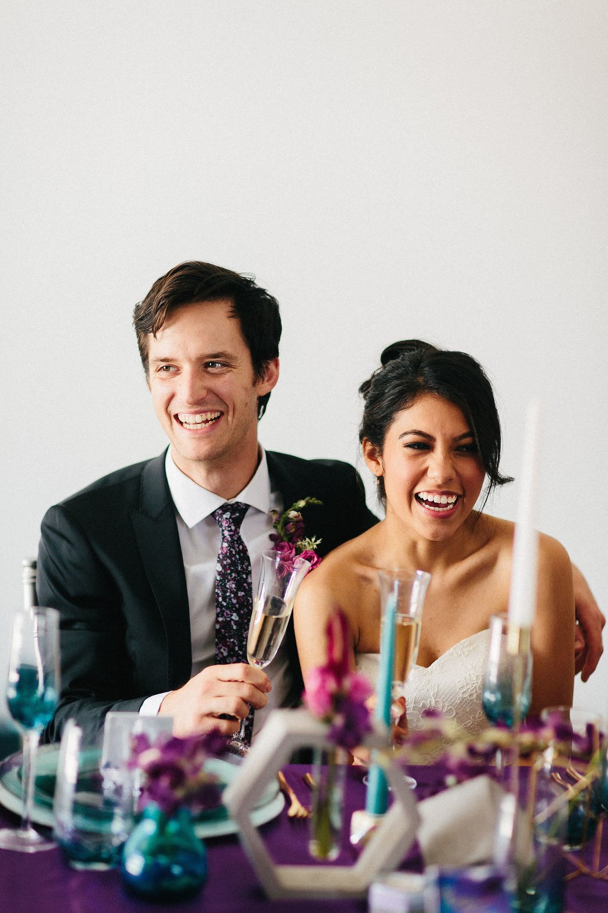 Smiling bride and groom at purple and teal wedding reception at Factory Atlanta