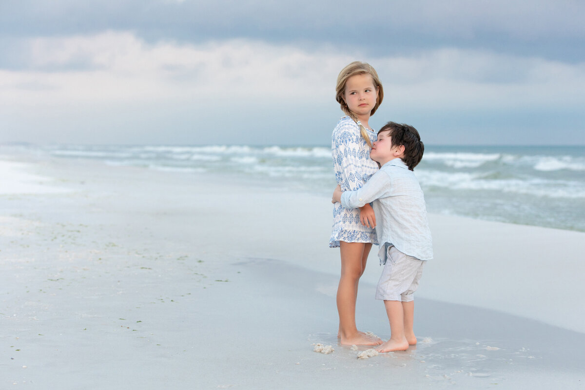 Two siblings hugging at the beach