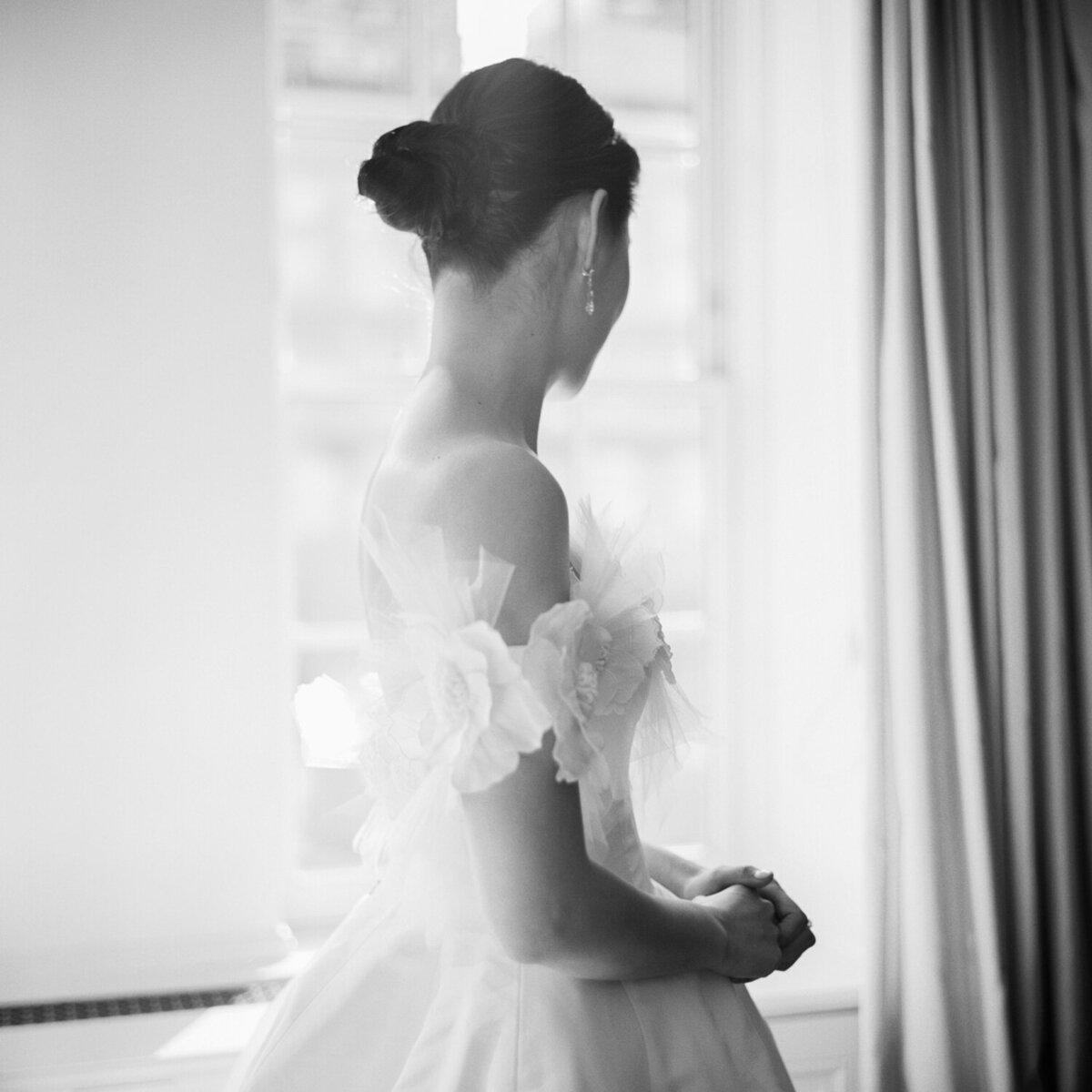 Bridal portrait in wedding gown in front of window NYC