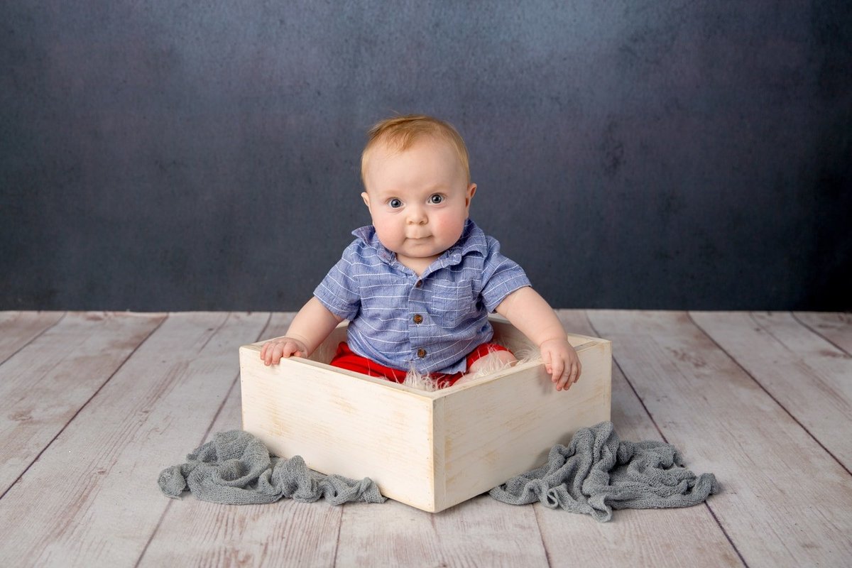 Milestone baby portrait of a baby boy on a blue background