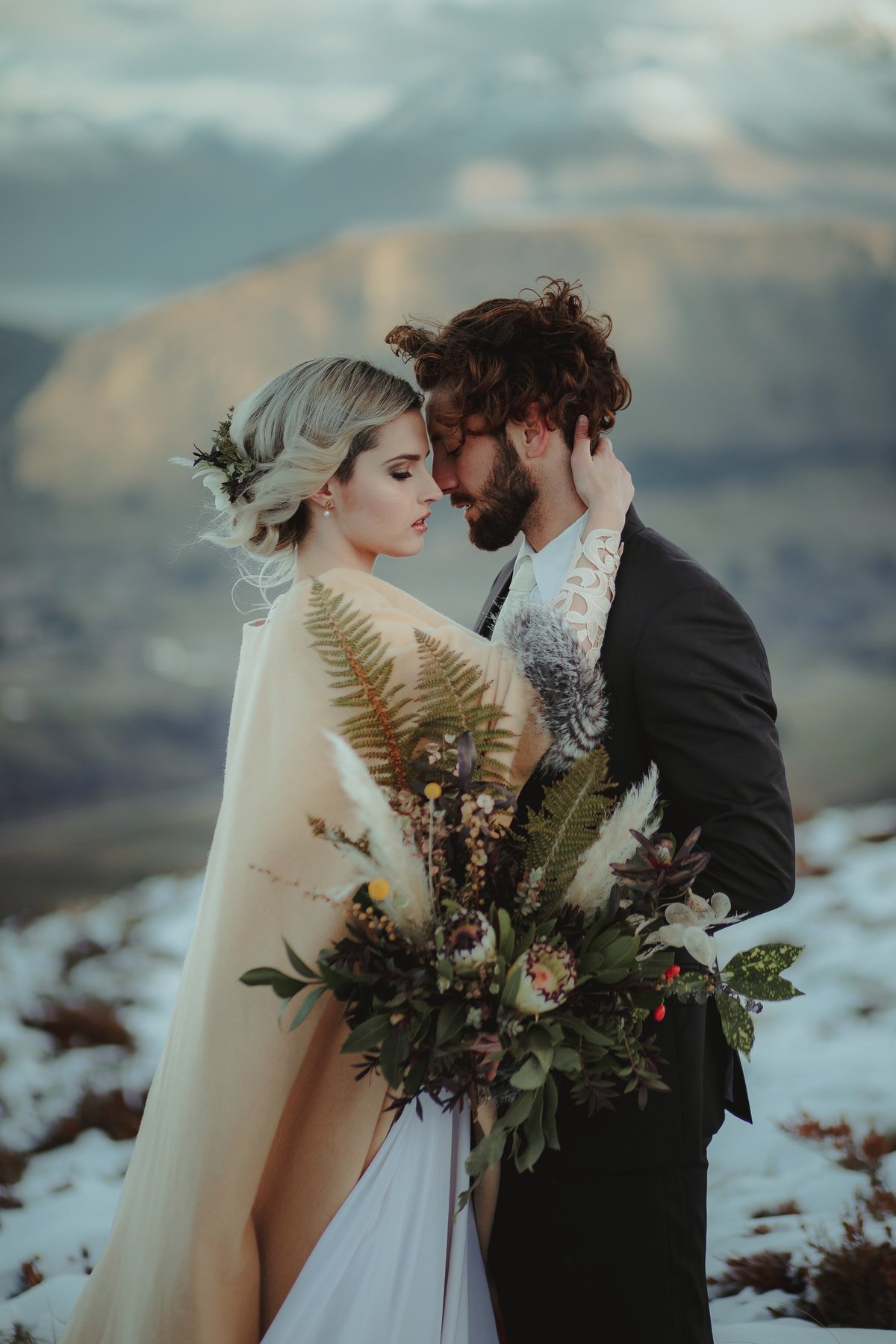 Bride and Groom holding each other close surrounded by snow
