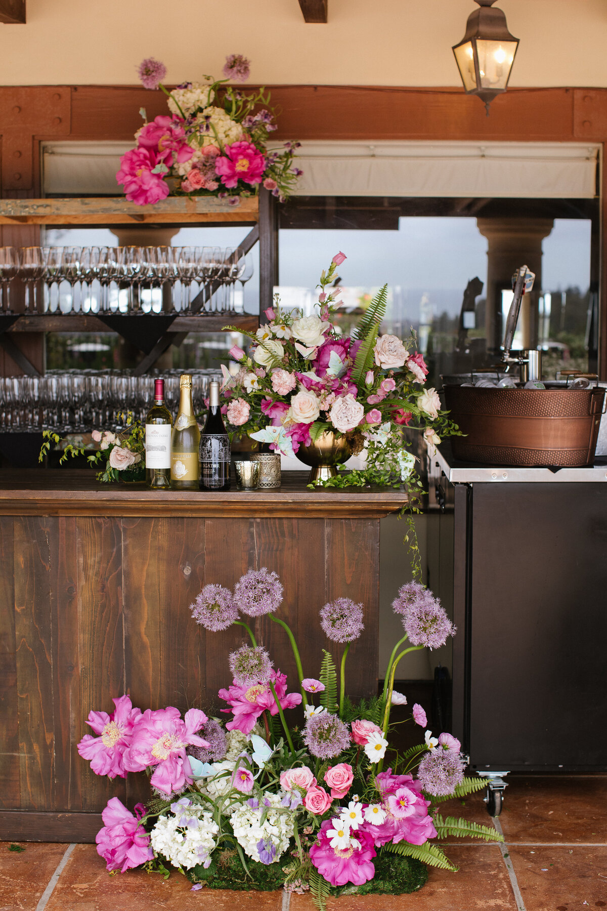 Pink and White flowers by a bar at a wedding