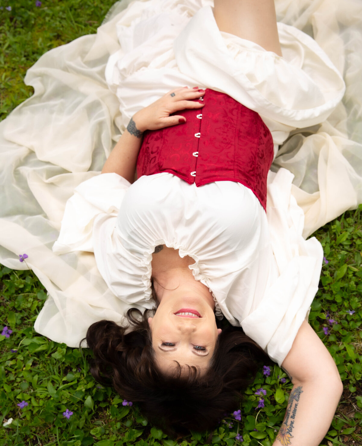 goddess studio boudoir romantic red corset flowing dress lay back on grass joy