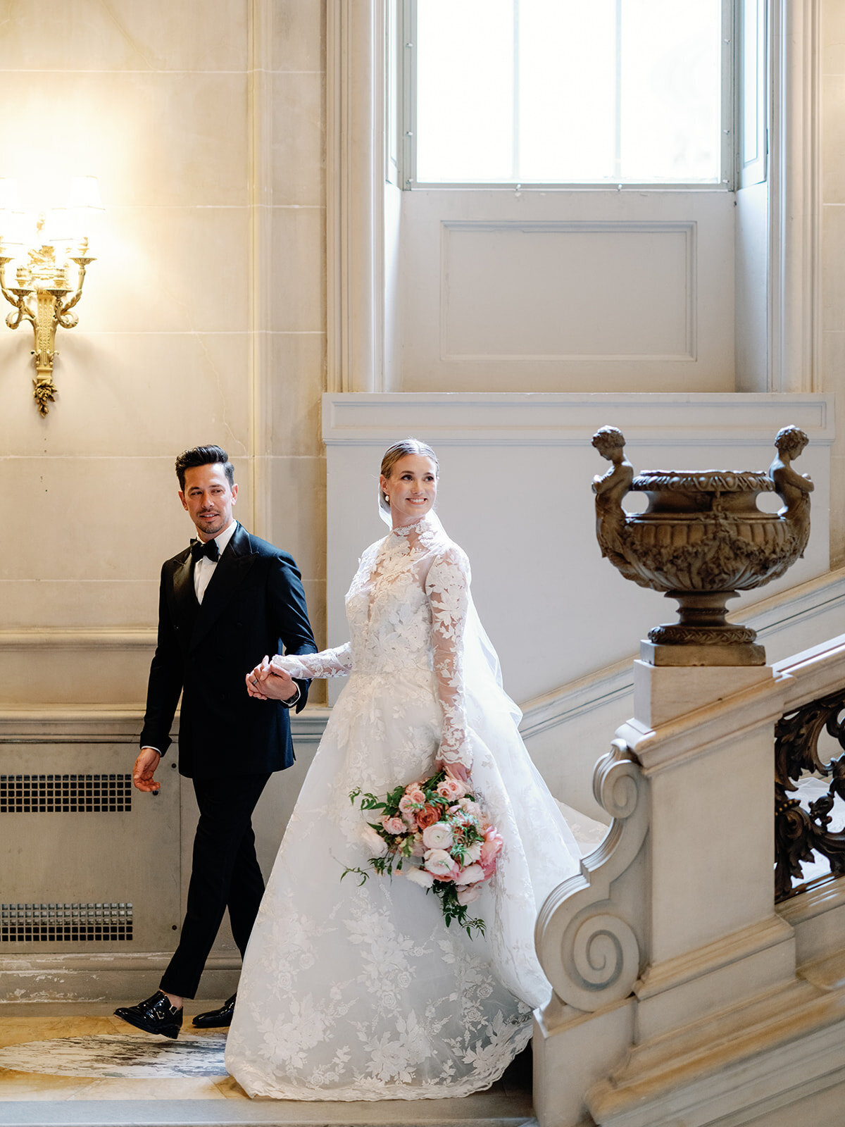 Bride and Groom walk down the grand steps in Larz Anderson house.