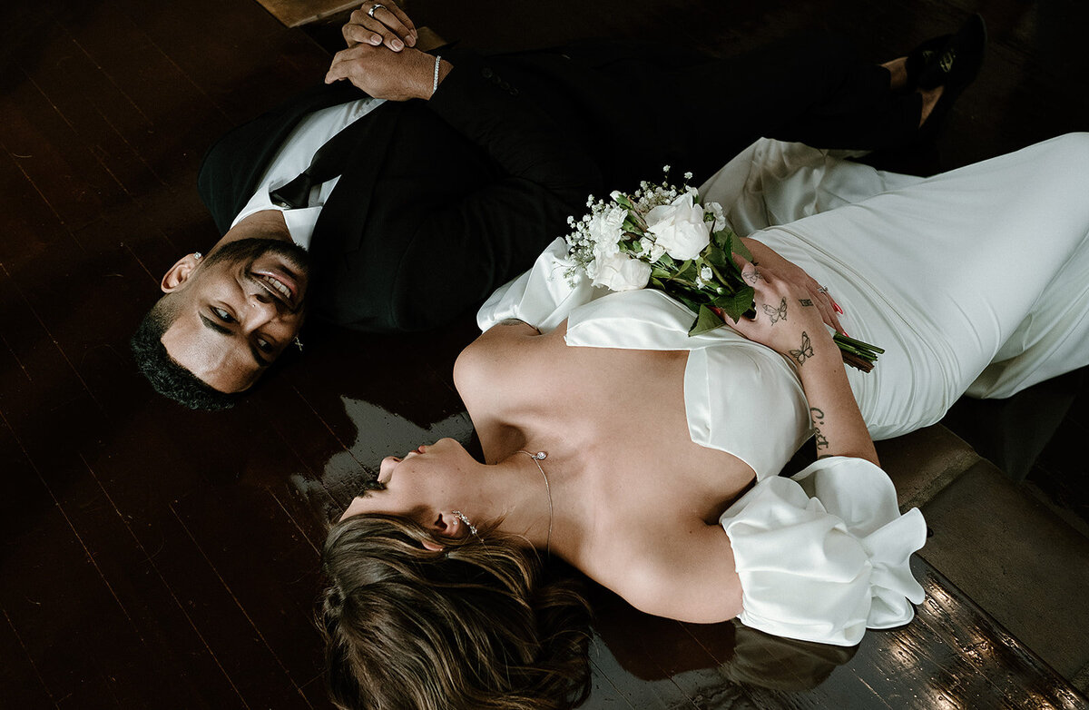 bride and groom lay together and smile at each other on the ceremony floor at Villa Parker