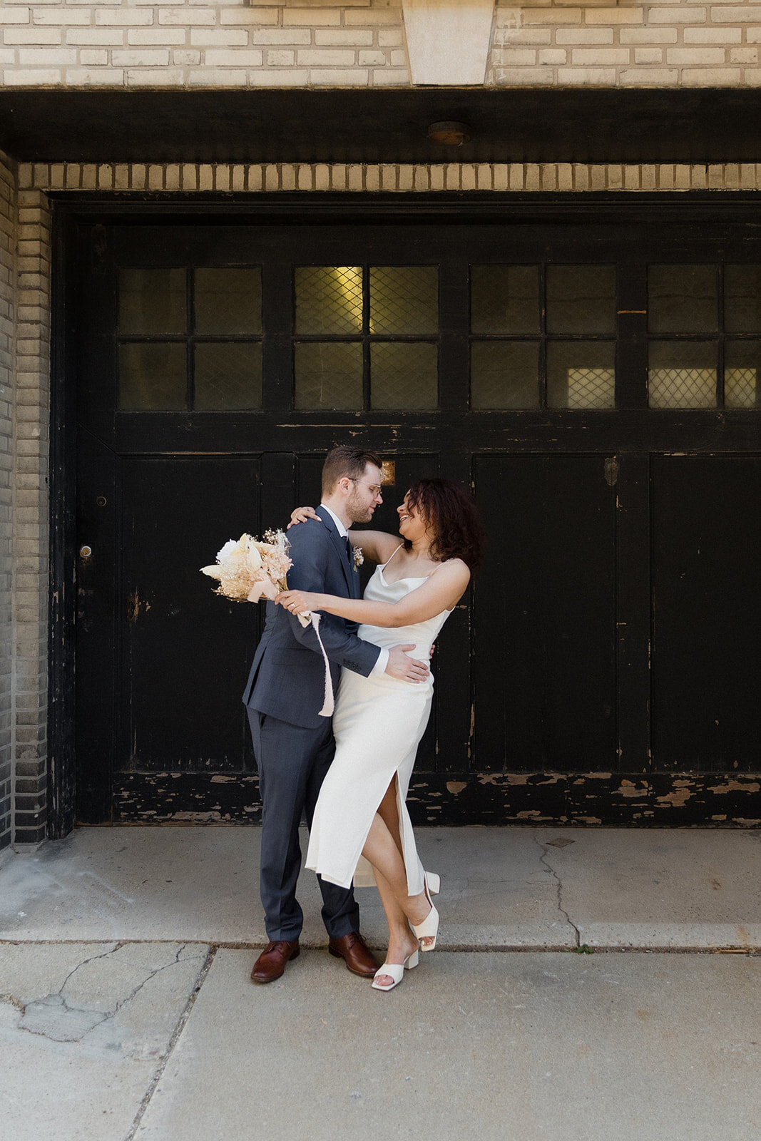 Just Married photo session urban alley photo of a couple embracing as groom dips bride.