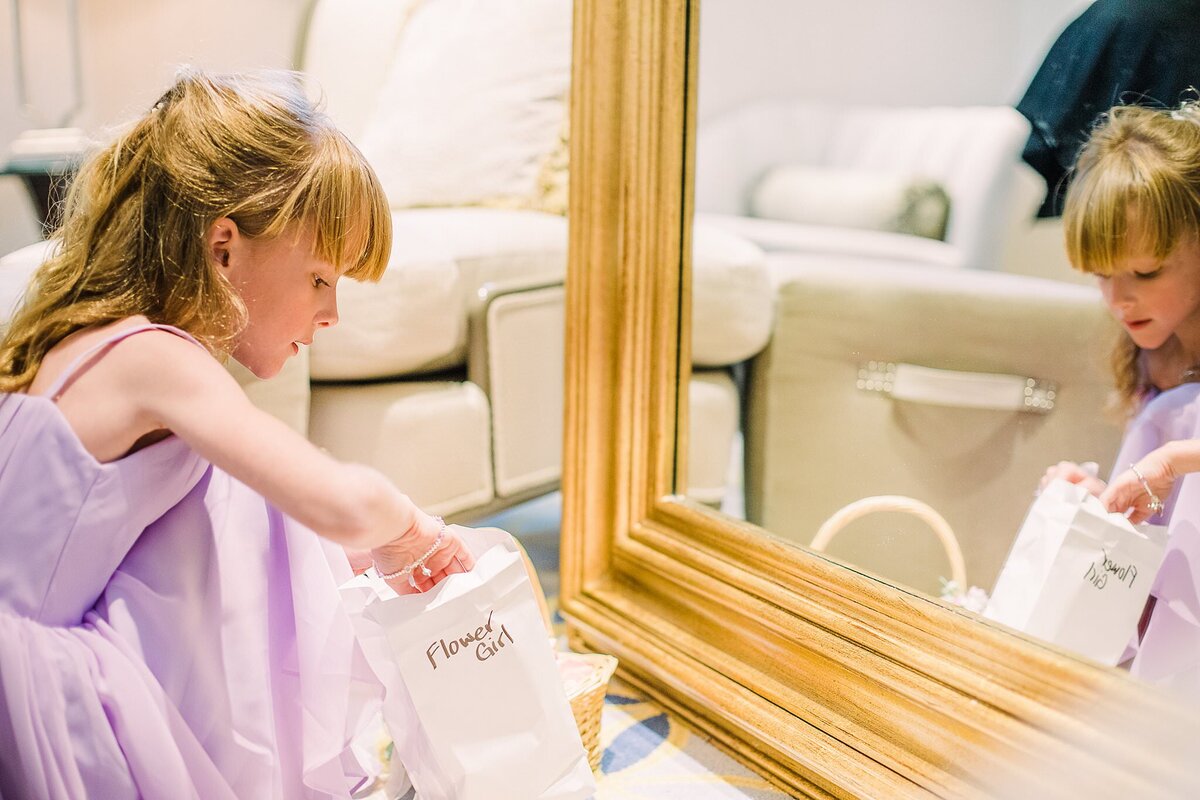 young  bridesmaid look at gift in mirror at wedding pavilion disney