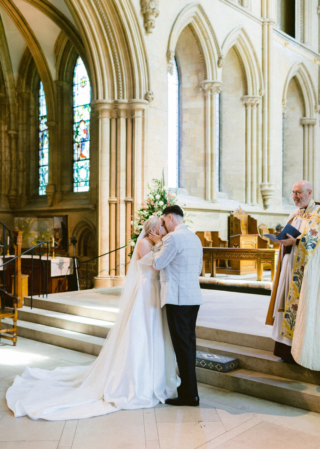bride and groom first kiss at the altar at cathedral wedding
