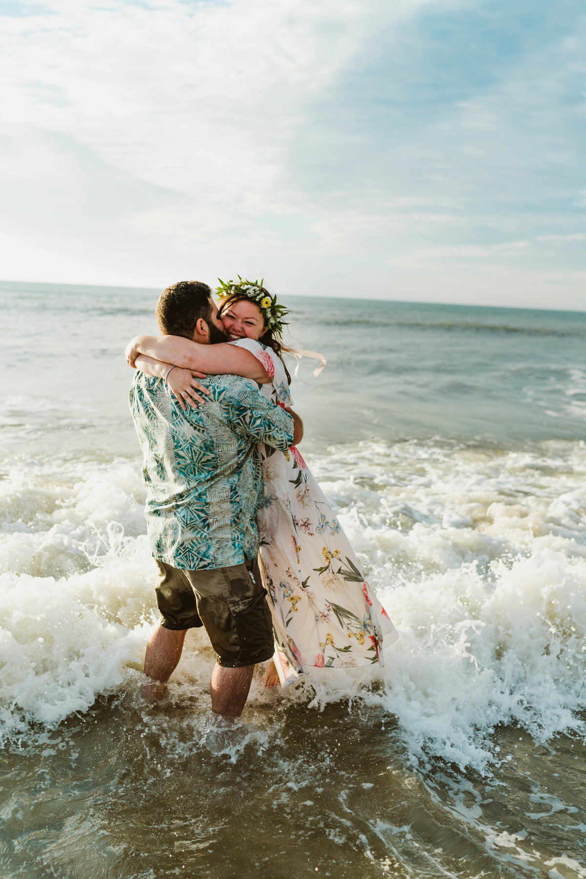 bride and groom embracing in the ocean after eloping