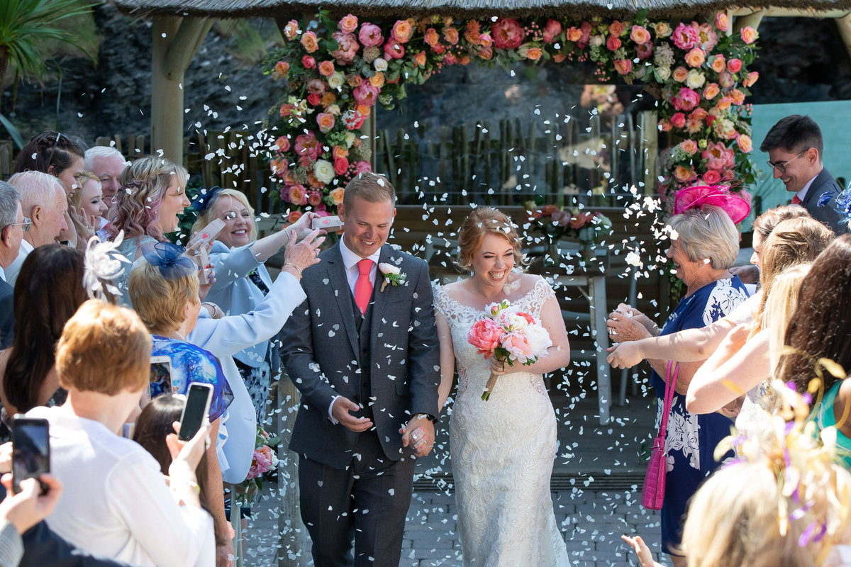 Walking down the aisle to confetti after wedding ceremony at Tunnels Beaches wedding in Devon