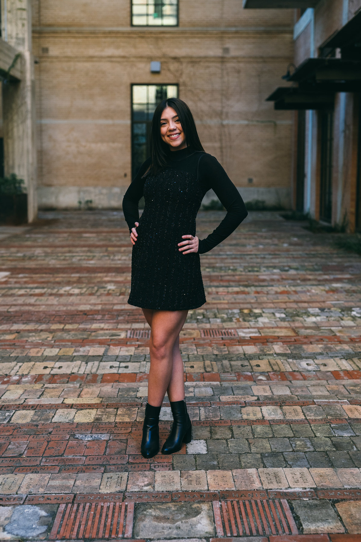 high school senior girl black dress with hands on hips by San Antonio senior photographer