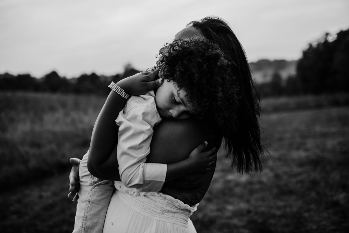 Mom and son embrace in field captured by ellicott city family photographer