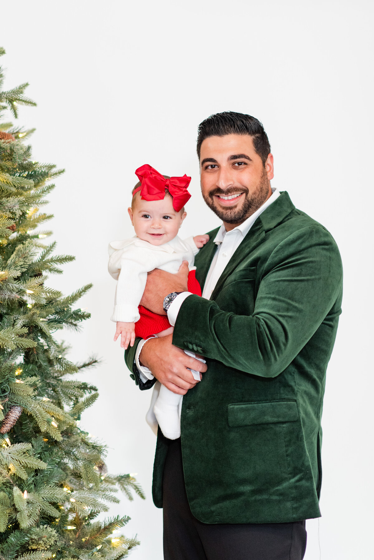 father and daughter in front of a Christmas tree by Miami Christmas Mini Session Photographer