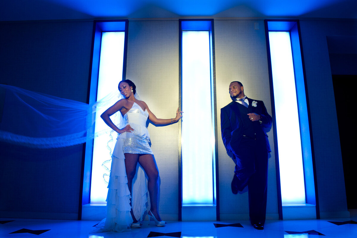 Bride and groom leaning to the wall with lights
