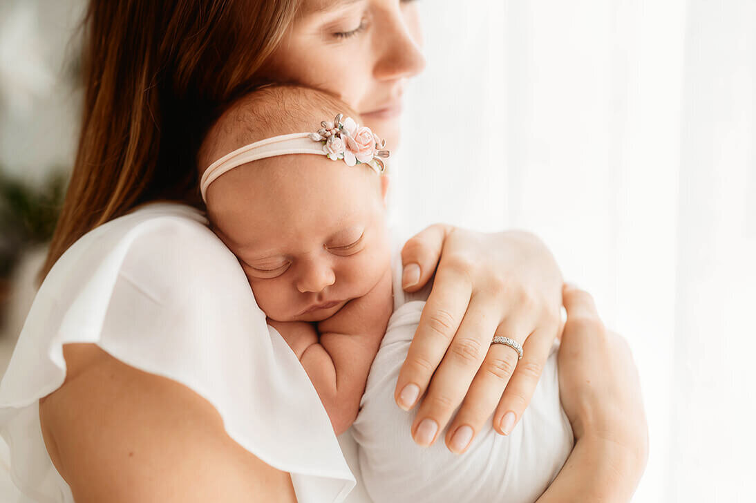 Mother embraces her infant during Newborn Photos in Asheville, NC.