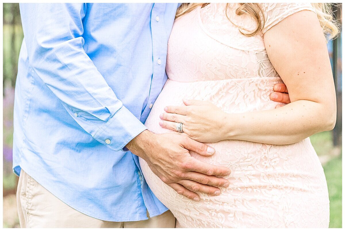 an outdoor Maternity Photography in Wexford where mom and dad and close and it is a close up picture of moms baby belly and both hands are on it.