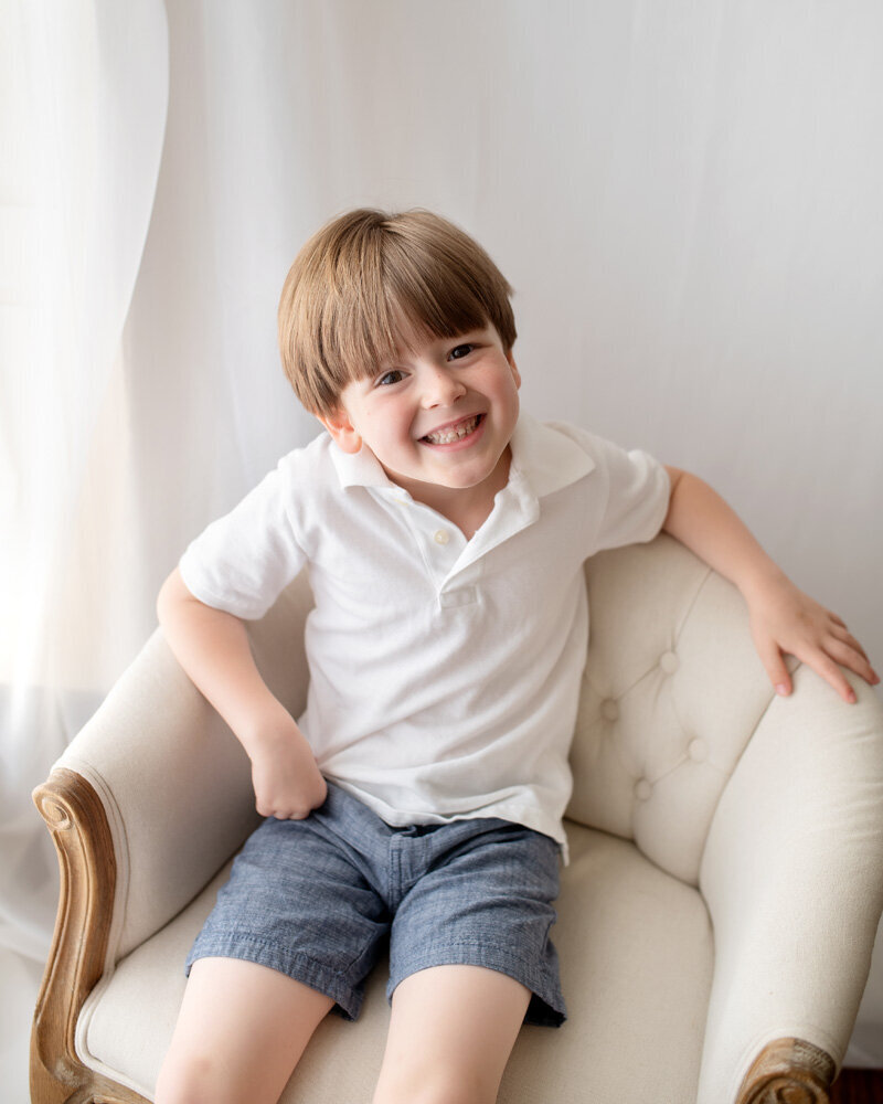 Family session of little boy sitting in a chair