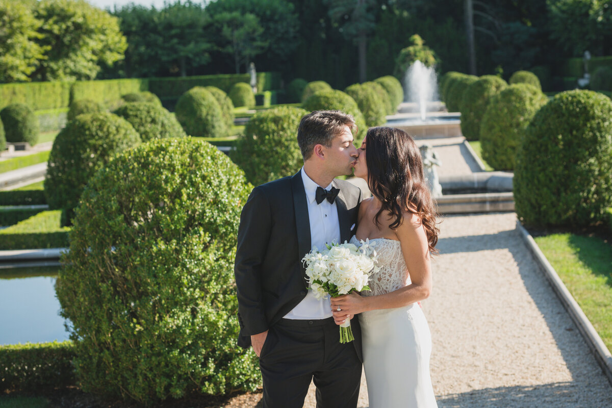 bride and groom kissing in the lawn at Oheka Castle
