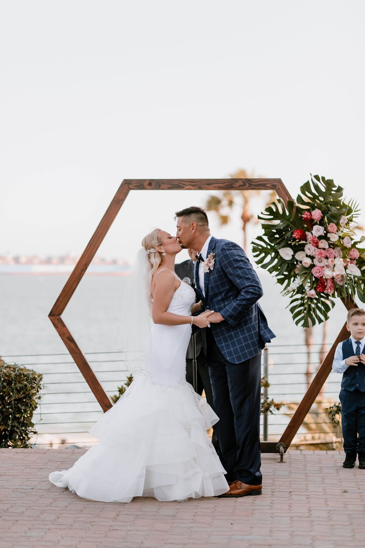 bride and groom kiss under hexagon shaped altar