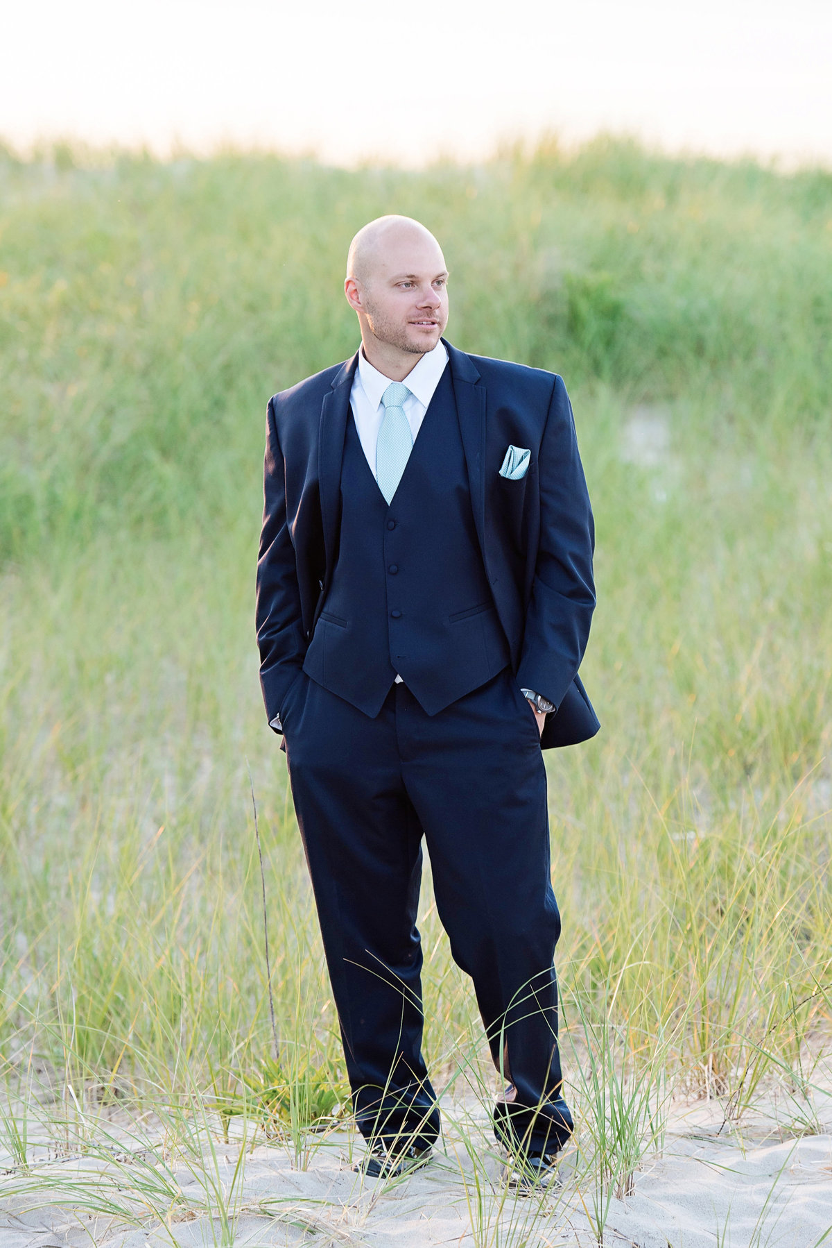 solo shot of groom with his hands in his pockets on the beach from wedding at Pavilion at Sunken Meadow