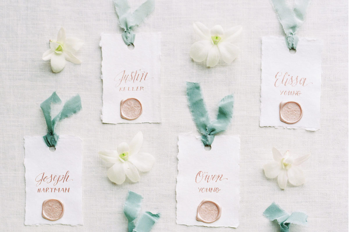 handmade paper escort cards with silk ribbon and champagne wax seal