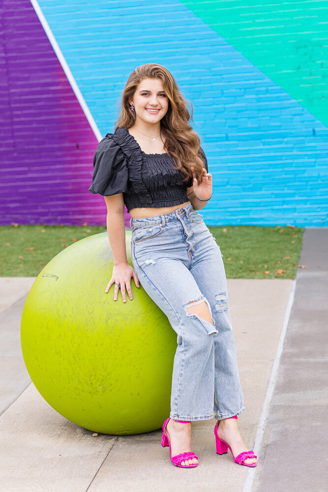 High school senior girl posing in front of a colorful mural in Raleigh, NC.