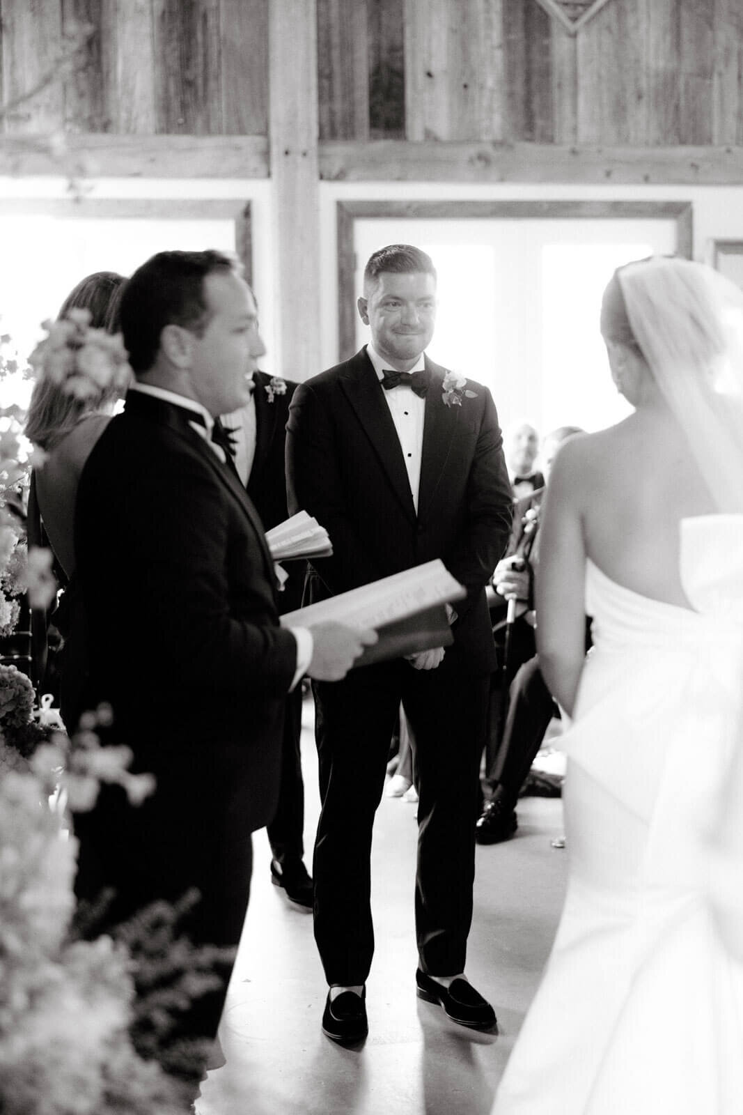 The groom is happily staring at the bride at a wedding ceremony in Lion Rock Farm, CT. Image by Jenny Fu Studio