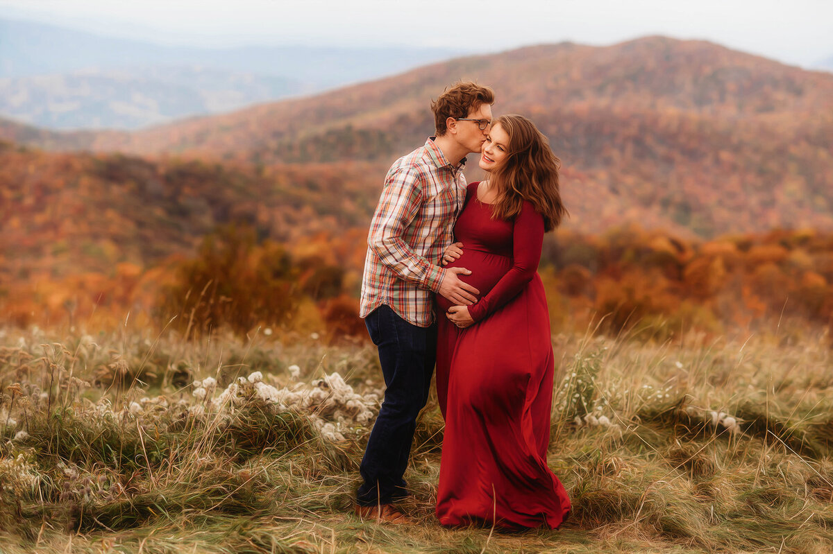 Expectant parents pose for photos during Family Photoshoot at Max Patch in Asheville, NC.