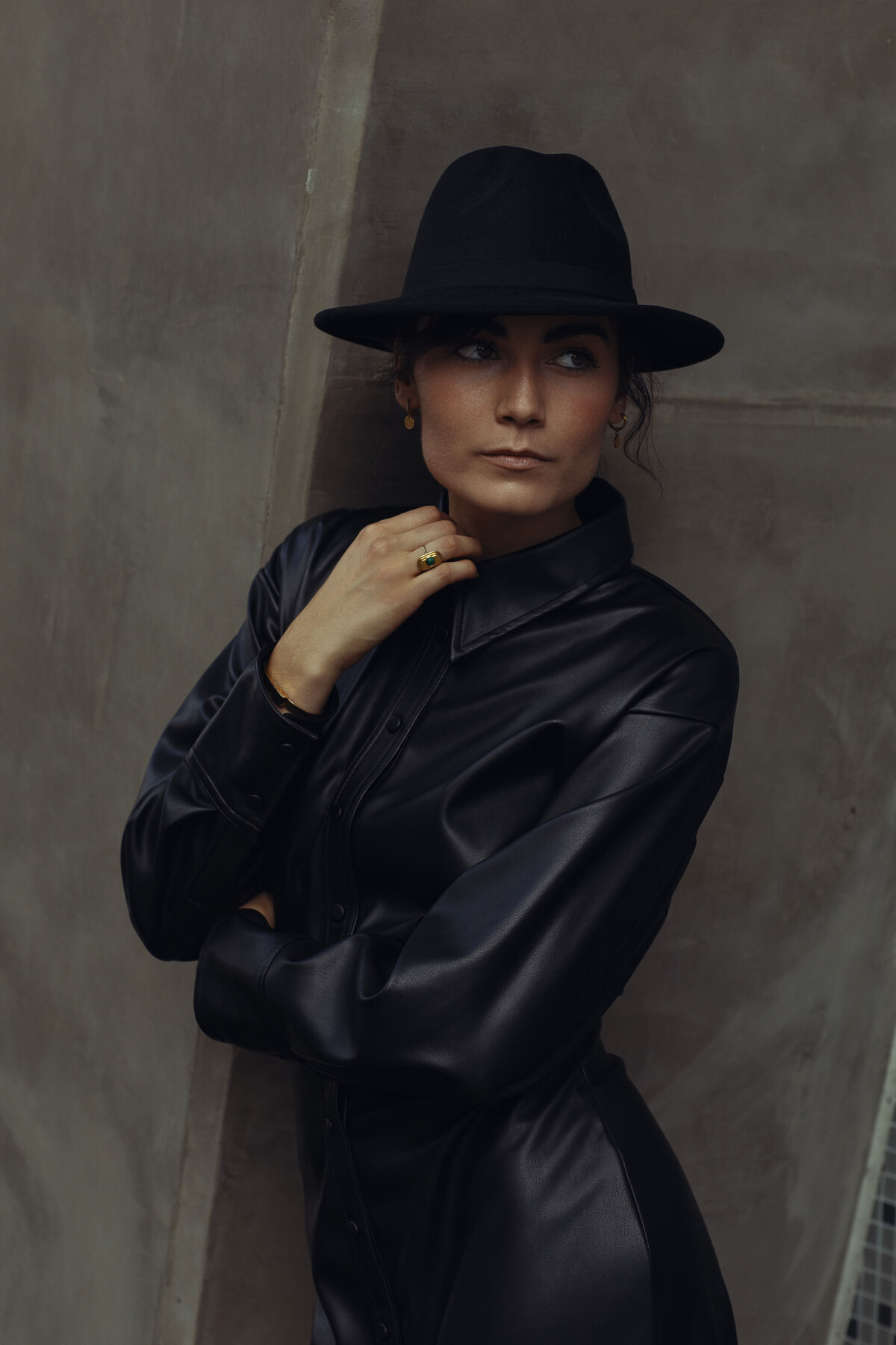 Portrait Photo Of Young Woman In Black Coat With One Hand Touching Her Neck Los Angeles