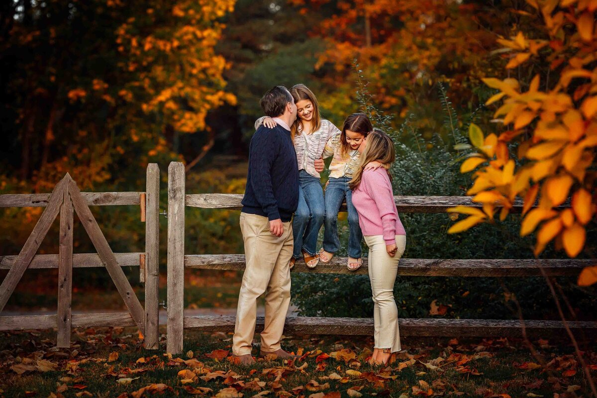 family hugging on fence