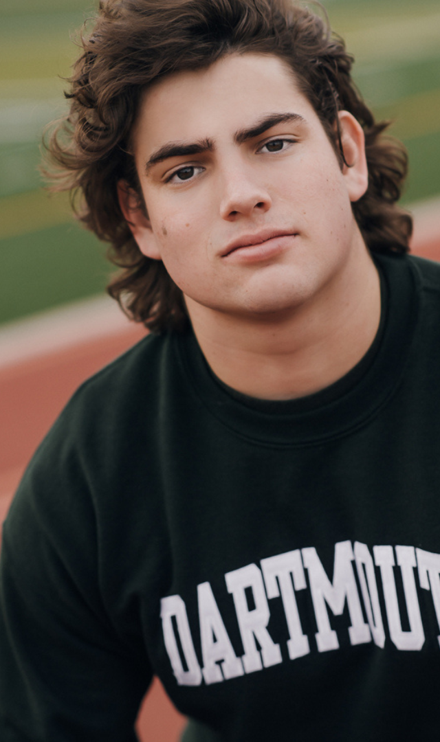 portrait of high school senior boy in a dartmouth sweatshirt
