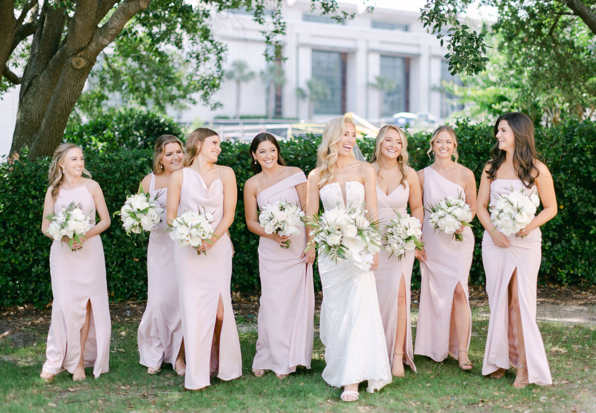 A bride laughs while backed by her bridesmaids.