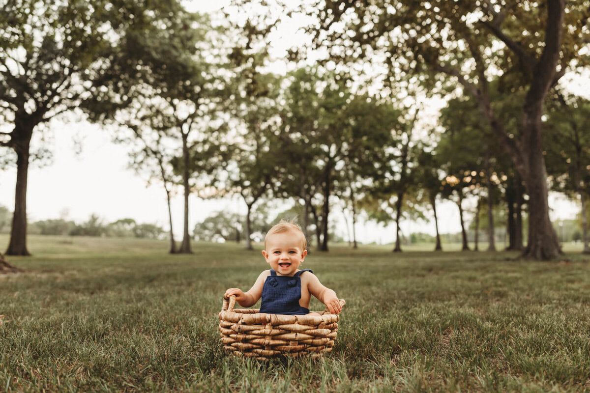 little boy sits in basket at park in pearland texas.