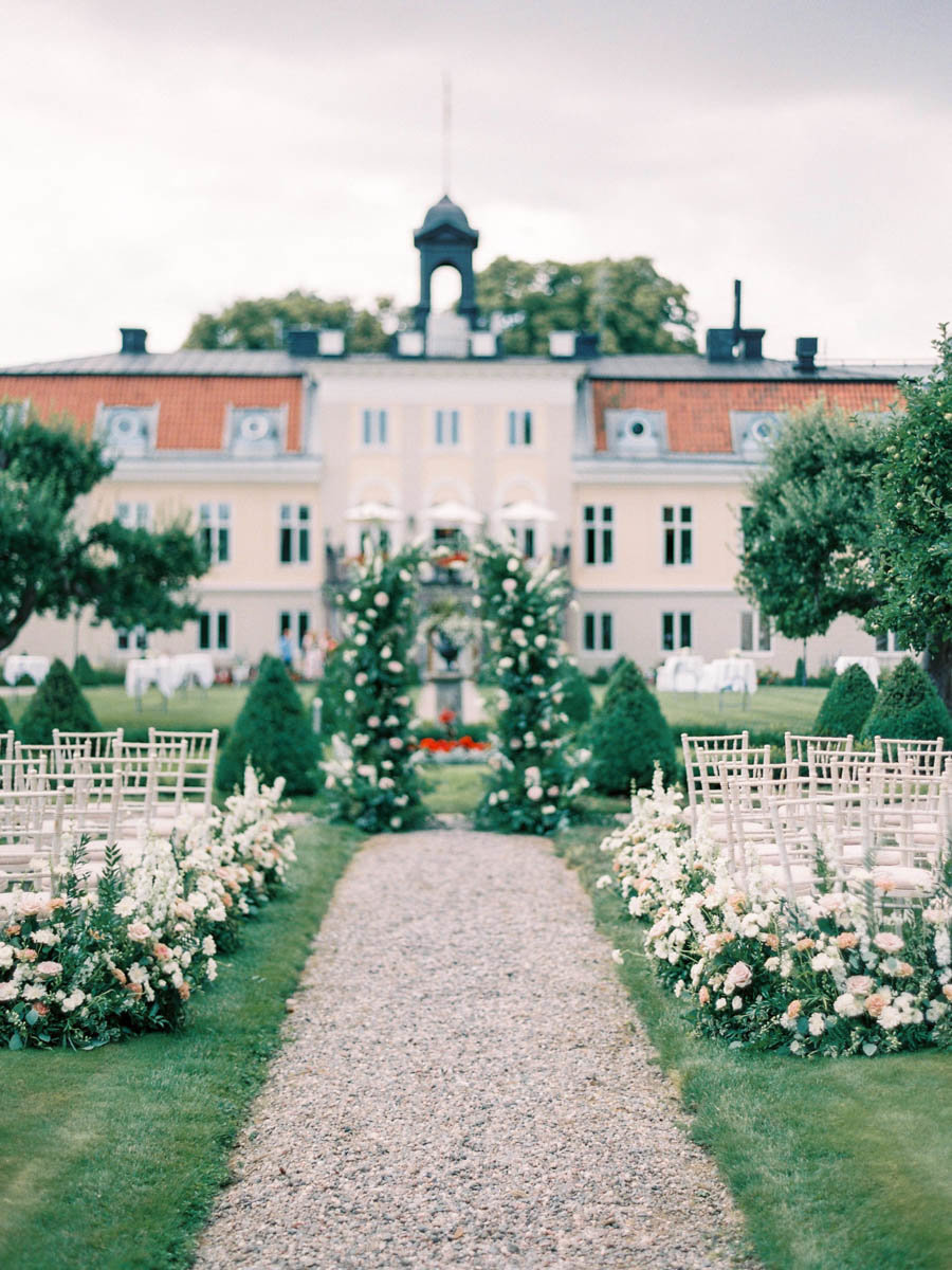 outdoor castle wedding ceremony with blush flower arrangements