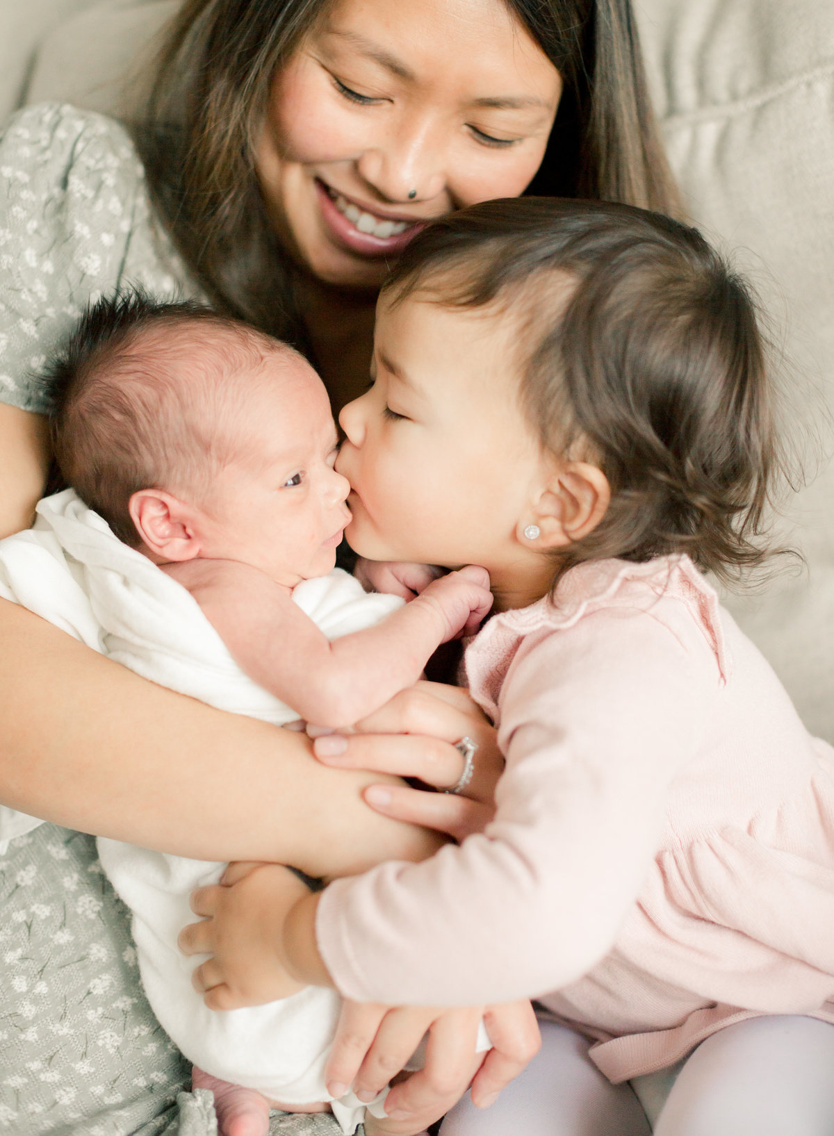 sister kisses newborn baby boy for family photography rochester minnesota
