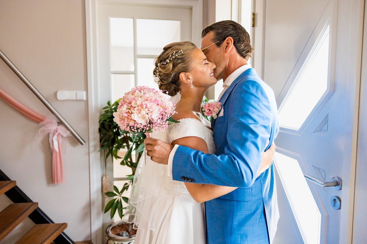 First look van het bruidspaar met een liefdevolle omhelzing tijdens hun bruiloft, perfect georganiseerd door weddingplanner en ceremoniemeester