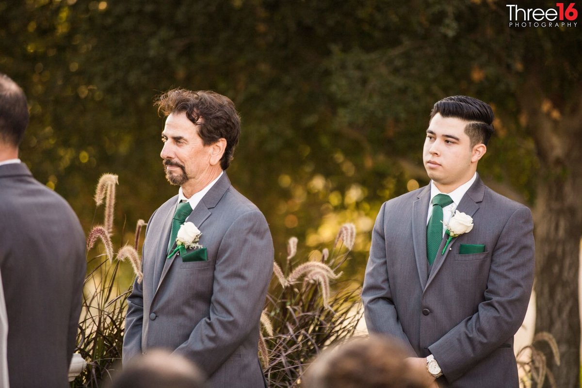 Groomsmen watch as the ceremony takes place