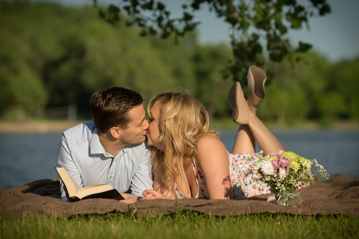 picnicking couple read poetry on the lake shore