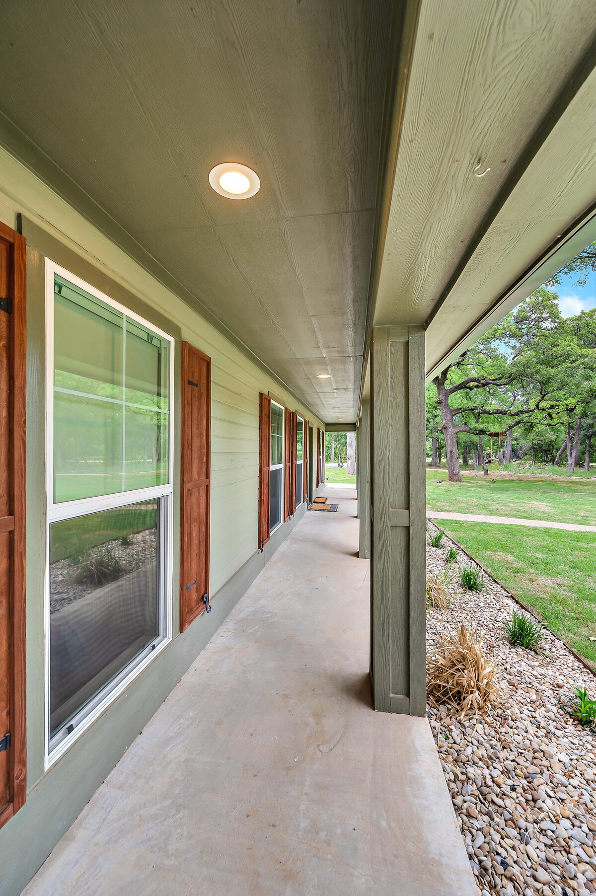 Beautiful front porch of this three-bedroom, three-bathroom vacation rental home with free wifi, outdoor theater, hot tub, propane grill and private yard in Waco, TX.
