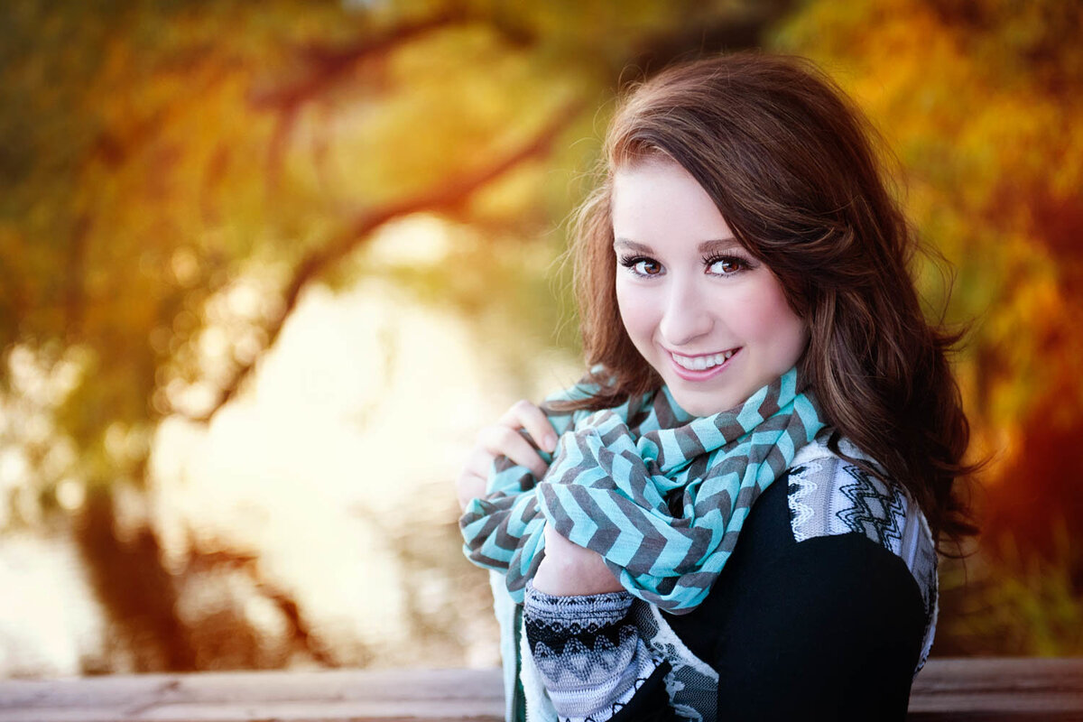 senior picture of girl with scarf in fall leaves