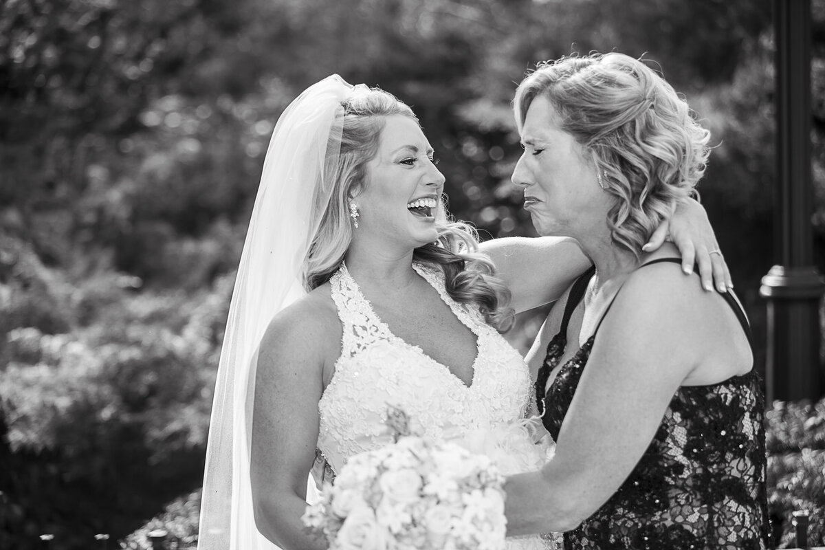A mother in tears sees her daughter for the first time in a wedding dress.