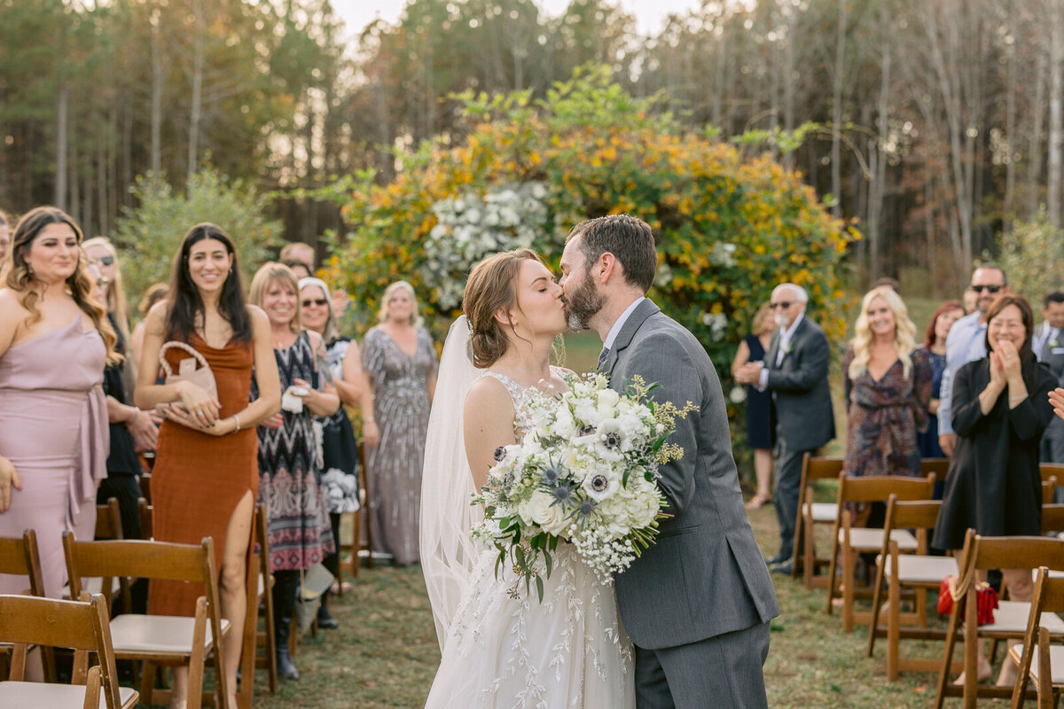 Wedding & Elopement Photographer, a bride and groom kiss during outdoor ceremony