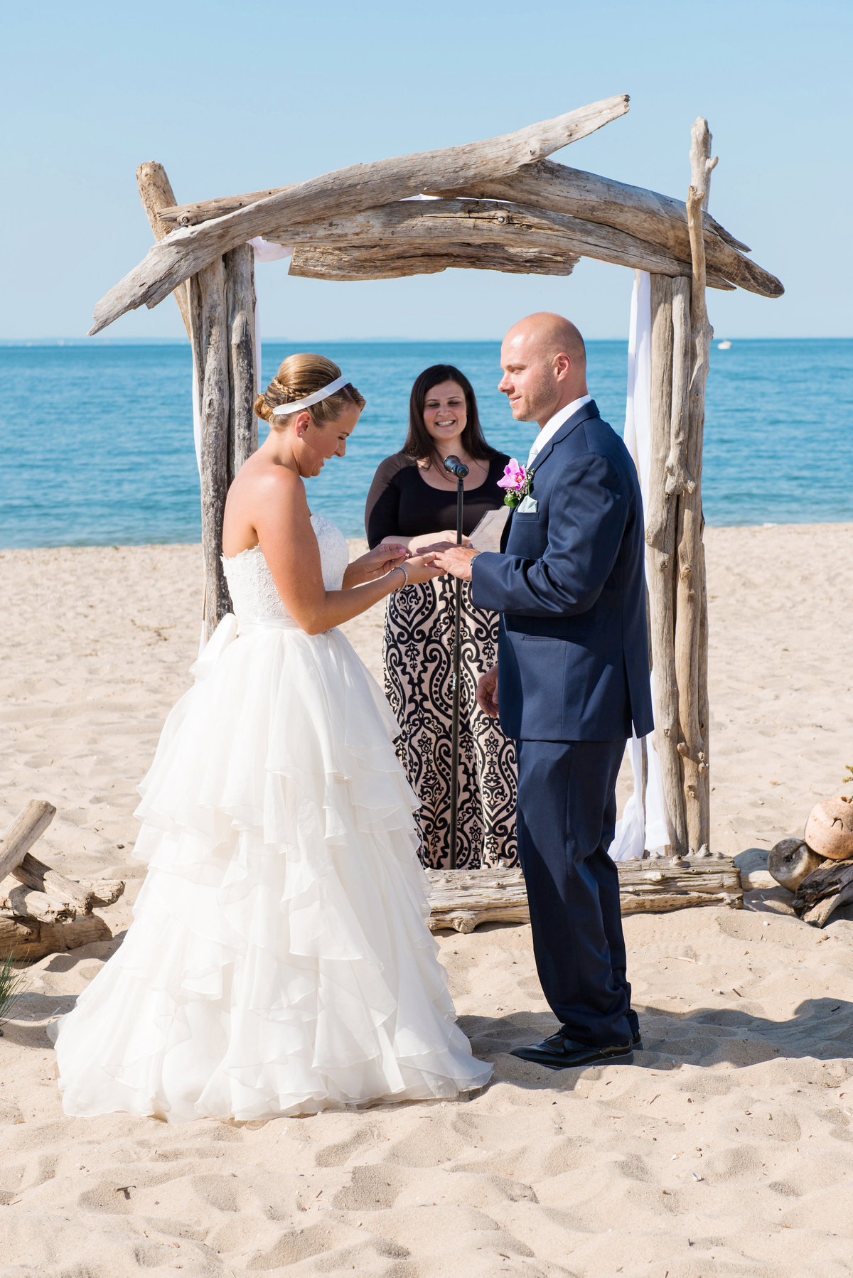 bride and groom ring exchange during wedding ceremony at Pavilion at Sunken Meadow