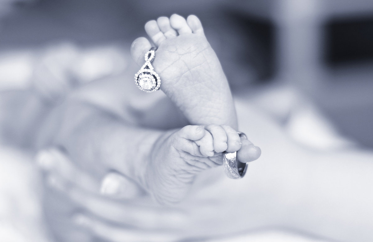 baby feet and wedding rings